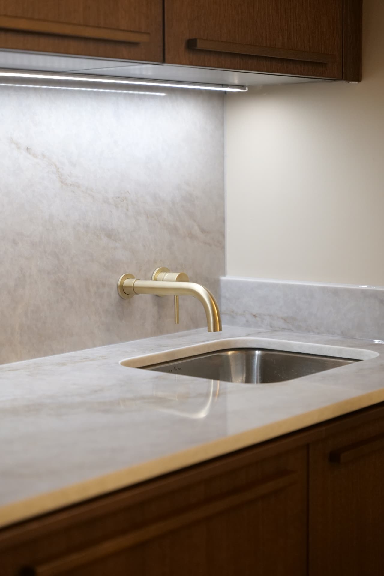 Stone worktop and brass tap at the hand-washing sink inside a Cobham Dental treatment room
