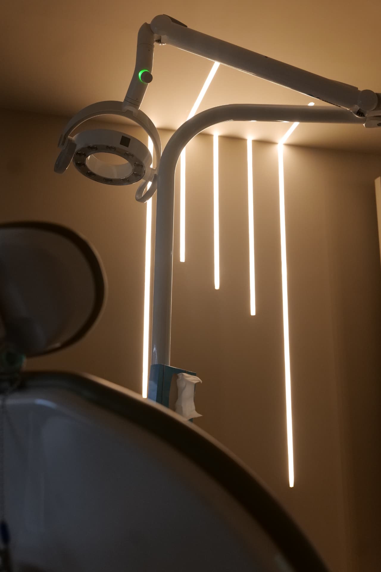A treatment room at Cobham Dental showing the dental chair headrest and the overhead operating light